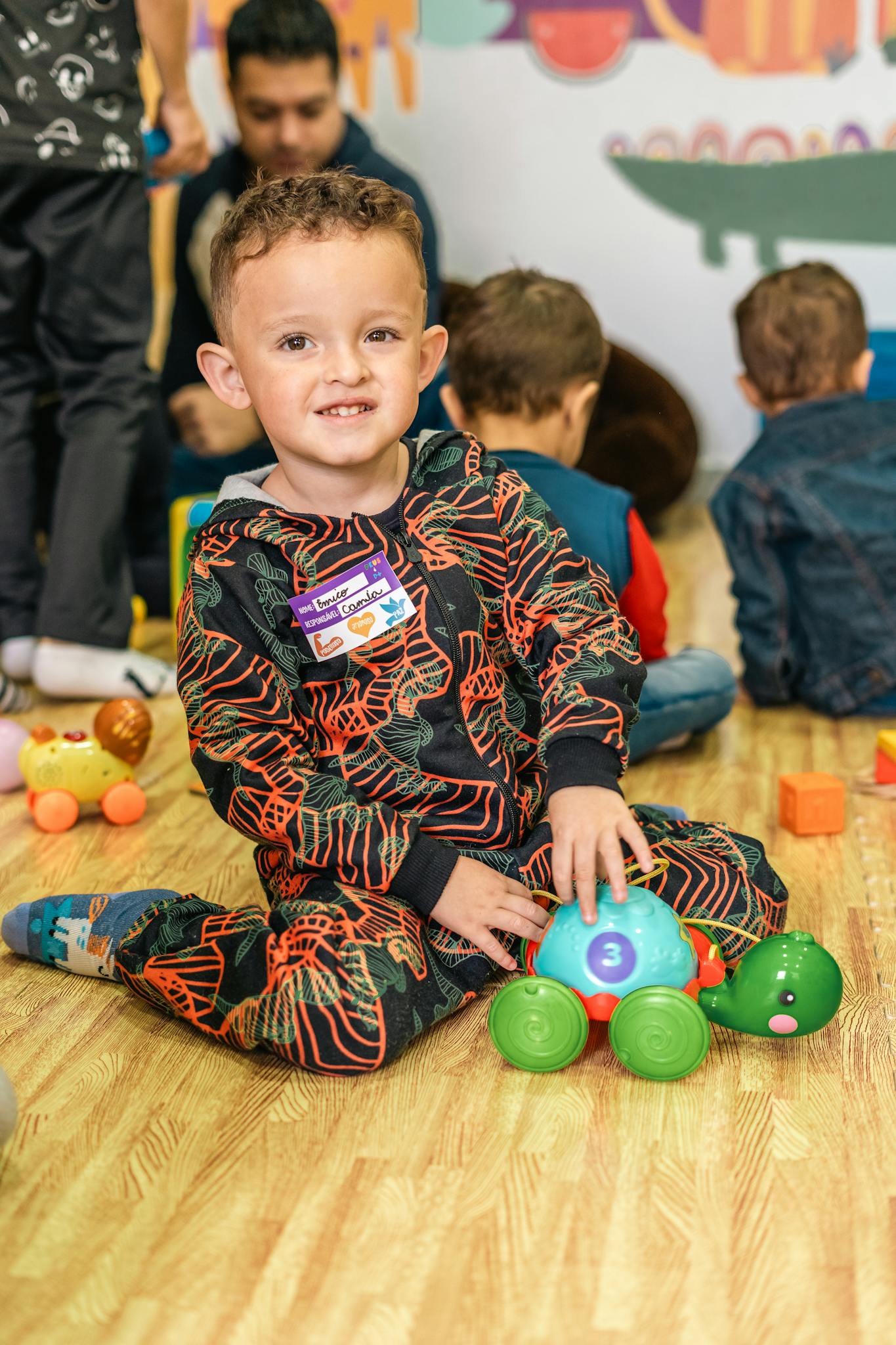 Joyful child playing with colorful toys on the floor in a vibrant indoor playroom.